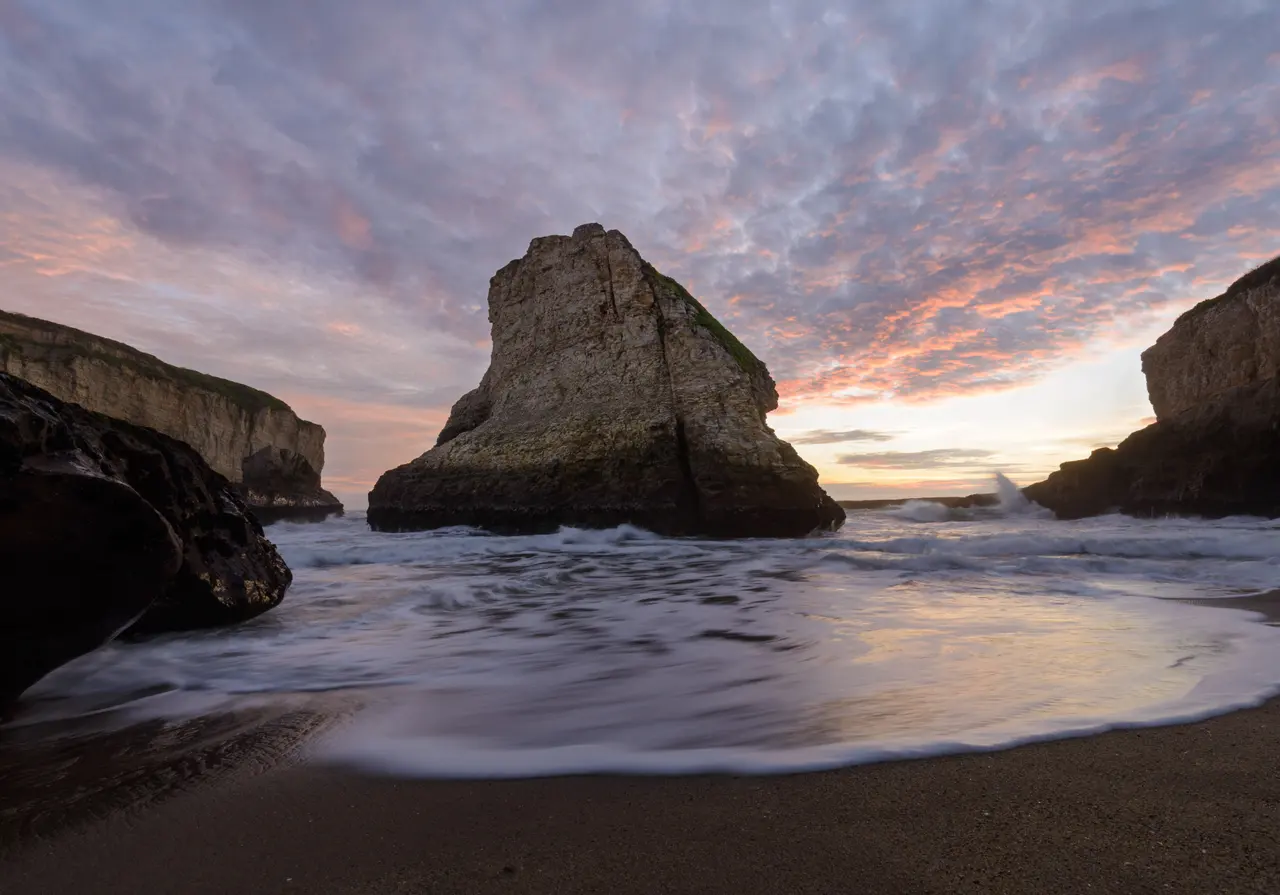 Shark Fin Cove under a soft pink and blue sunset